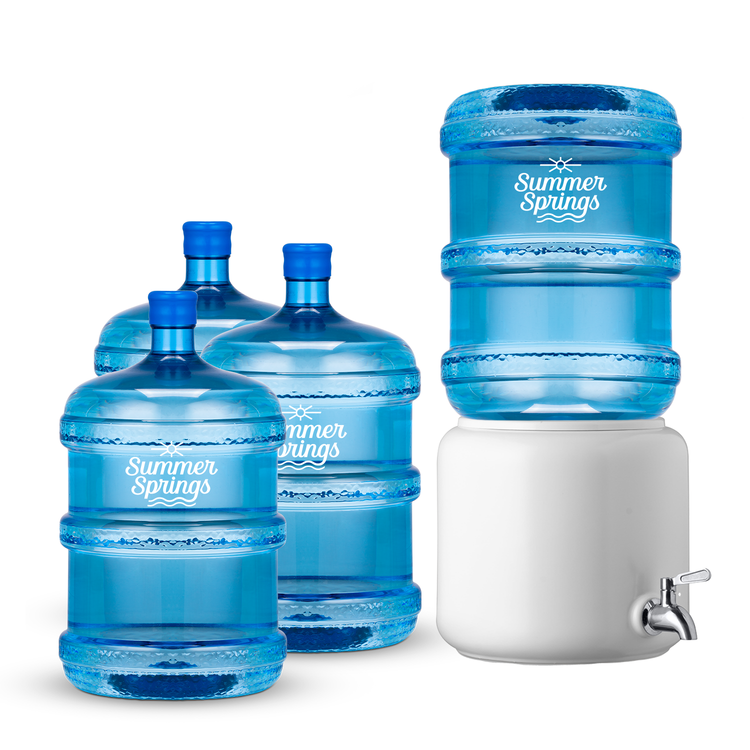 A white ceramic water dispenser with chrome tap, alongside four blue water bottles with labels.